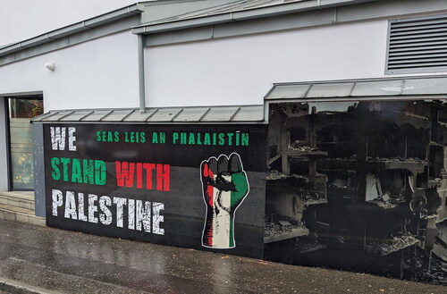 Figure 2. Image of mural with fist and “we stand with Palestine,” painted in 2023 during the ongoing genocidal assault on Gaza.Source: Photo taken by Brendan Ciarán Browne, 2023.