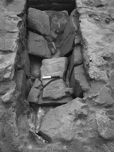 Figure 6. The cist burial viewed from the north, showing the covering slabs collapsed onto the underlying lead coffin lining.