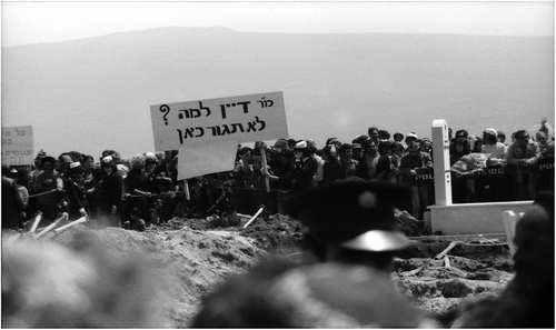 Protest at the funeral in Kiryat Shmona. The sign reads: “Mr. Dayan why won’t you live here?” Photographer: Avraham Eilat.